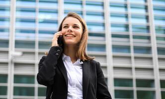 Porträt einer jungen Frau, die am Telefon spricht foto