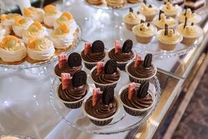 ein köstlich Hochzeit. Cupcakes, Kuchen. Süßigkeiten Bar zum ein Bankett. Feier Konzept. modisch Nachspeisen. Tabelle mit Süßigkeiten, Süßigkeiten. Früchte foto