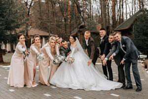 Braut und Bräutigam umarmen, posieren mit Freunde. freunde sind haben Spaß. glücklich Momente. Hochzeit Porträt im Natur, Hochzeit Foto im Licht Farben.