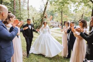 in voller Länge Porträt von das Jungvermählten und ihr freunde beim das Hochzeit. das Braut und Bräutigam mit Brautjungfern und freunde von das Bräutigam sind haben Spaß und Jubel beim das Hochzeit. foto