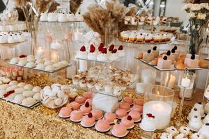 Süßigkeiten Bar zum ein Hochzeit. Süßigkeiten Bar Stehen festlich Tabelle mit Nachspeisen, Cupcakes und Macarons. schön und lecker. foto