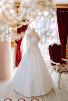 Schlafzimmer Innere mit Hochzeit Kleid bereit zum das Zeremonie. ein schön üppig Hochzeit Kleid auf ein Mannequin im ein Hotel Zimmer. foto