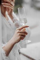 Luxus Frau tragen ein Weiß Kleid halten ein Glas von Champagner Nahansicht. draussen Party Konzept. foto