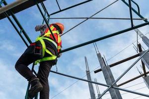 Höhenarbeiten von Arbeitern in Sicherheitskleidung auf der Baustelle foto