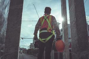 ziviler Mann mit Helmständer auf der Baustelle foto