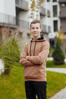 Vertikale Nahansicht Porträt von ein Teenager im beiläufig Kleidung. glücklich lächelnd Teenager im Herbst Park im Sonnenlicht. ein schön Kind sieht aus beim das Kamera im Natur. foto