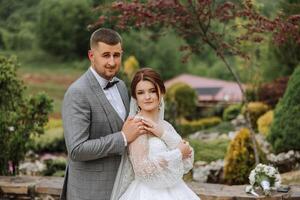 Hochzeit. Liebe und Paar im Garten zum Hochzeit. Feier von Zeremonie und Engagement. speichern das Datum. Vertrauen. das Braut und Bräutigam umarmen. das Bräutigam umarmt das Braut im das Frühling Landschaft. foto