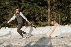 das Braut und Bräutigam Reiten ein Schlitten auf ein schneebedeckt Straße im Winter. Winter Hochzeit auf das Straße im das Wald. das Winter Feiertage. glücklich Paar Rodeln im schneebedeckt Winter Wetter foto