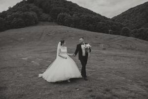 Porträt von ein jung Braut und Bräutigam Gehen auf Grün Gras im ein groß Feld nach das Hochzeit Zeremonie, Vorderseite Sicht. glücklich Hochzeit Paar, Kopieren Raum foto