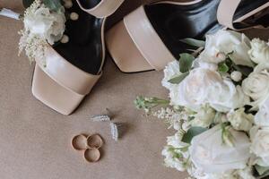Einzelheiten von das Braut. Schönheit ist im das Einzelheiten. hochhackig Braut- Schuhe. Gold Hochzeit Ring mit ein Diamant. Parfums. Ohrringe Hochzeit im Einzelheiten. foto