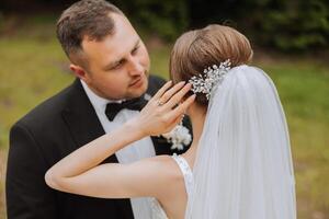 Hochzeit. Liebe und Paar im Garten zum Hochzeit. Feier von Zeremonie und Engagement. speichern das Datum. Vertrauen das Bräutigam umarmt das Braut im das Berge auf das Hintergrund von das Wald foto