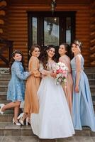 Gruppe Porträt von das Braut und Brautjungfern. ein Braut im ein Hochzeit Kleid und Brautjungfern im schön Kleider halt das Braut Strauß auf das Hochzeit Tag. foto
