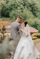 Hochzeit. Liebe und Paar im Garten zum Hochzeit. Feier von Zeremonie und Engagement. speichern das Datum. Vertrauen. das Braut und Bräutigam umarmen. das Bräutigam umarmt das Braut im das Frühling Landschaft. foto