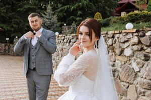 ein schön jung Braut, im ein Sommer- Park, Spaziergänge voraus von ihr Bräutigam. schön Hochzeit Weiß Kleid. Spaziergänge im das Park. ein glücklich und liebend Paar. foto