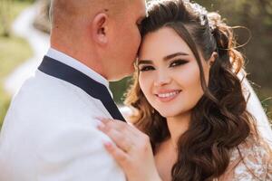 Hochzeit. Liebe und Paar im Garten zum Hochzeit. Feier von Zeremonie und Engagement. speichern das Datum. Vertrauen. das Braut und Bräutigam umarmen. Lächeln und Liebe im das Park. das Bräutigam umarmt das Braut. foto