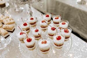 Süßigkeiten Bar zum ein Hochzeit. Süßigkeiten Bar Stehen festlich Tabelle mit Nachspeisen, Cupcakes und Macarons. schön und lecker. foto