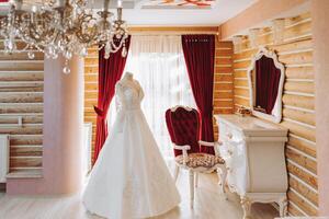 Schlafzimmer Innere mit Hochzeit Kleid bereit zum das Zeremonie. ein schön üppig Hochzeit Kleid auf ein Mannequin im ein Hotel Zimmer. foto