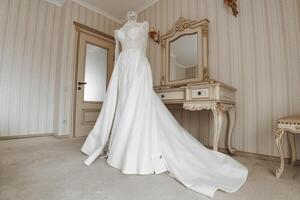 Hochzeit Kleid im das Innere von das Hotel, bereit zum das Zeremonie. Hochzeit Kleid mit Ärmel und geschlossen Schultern foto