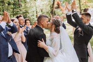 in voller Länge Porträt von das Jungvermählten und ihr freunde beim das Hochzeit. das Braut und Bräutigam mit Brautjungfern und freunde von das Bräutigam sind haben Spaß und Jubel beim das Hochzeit. foto