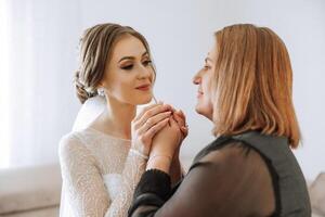 ein schön und glücklich Mutter und ihr Tochter, das Braut, sind Stehen Nächster zu jeder andere. das Beste Tag zum Eltern. zärtlich Momente beim das Hochzeit. foto