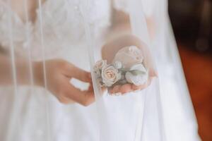 Hochzeit Boutonniere von Blumen im das Hände von das Braut. Hochzeit Einzelheiten. das zuerst Treffen von das Braut und Bräutigam. das Braut ist warten zum das Bräutigam. foto