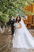 ein schön jung Braut, im ein Sommer- Park, Spaziergänge voraus von ihr Bräutigam. schön Hochzeit Weiß Kleid. Spaziergänge im das Park. ein glücklich und liebend Paar. foto