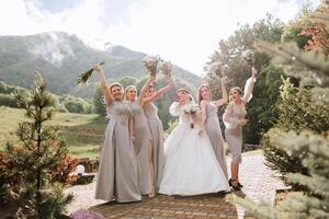 Gruppe Porträt von das Braut und Brautjungfern. ein Braut im ein Hochzeit Kleid und Brautjungfern im Silber Kleider halt stilvoll Blumensträuße auf ihr Hochzeit Tag. foto