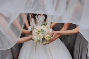 Gruppe Porträt von das Braut und Brautjungfern. ein Braut im ein Hochzeit Kleid und Brautjungfern im Silber Kleider halt stilvoll Blumensträuße auf ihr Hochzeit Tag. foto