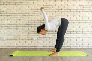 lateinische frau, die yoga auf matte praktiziert foto