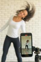Latin Woman hat ihr Tanzvideo mit der Smartphone-Kamera erstellt. um Videos an Social-Media-Anwendungen zu teilen.