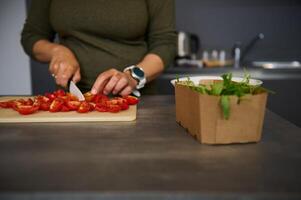 Nahansicht Frau Hausfrau Schneiden Tomaten, vorbereiten frisch Salat, Stehen beim Küche Tabelle foto