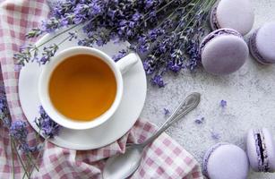 Tasse Tee mit Makronen-Dessert mit Lavendelgeschmack foto