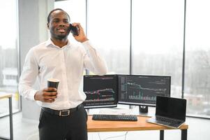Afroamerikaner Makler funktioniert im Büro mit Arbeitsplatz und Analyse Technologie foto