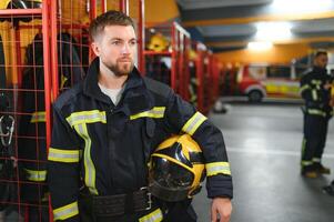 ein Feuerwehrmann setzt auf ein Feuer Uniform beim das Feuer Abteilung foto