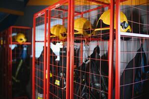 Helme und Uniformen im Schließfach Zimmer von Feuer Kämpfer foto