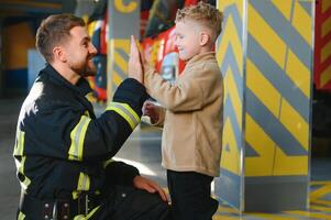 Feuerwehrmann halten Kind Junge zu speichern ihm im Feuer und Rauch, Feuerwehrleute Rettung das Jungs von Feuer foto