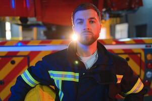 Feuerwehrmann Porträt auf Pflicht. Feuerwehrmann mit Helm in der Nähe von Feuer Motor foto