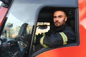 Seite Aussicht von Feuerwehrmann im schützend Uniform Fahren Feuer Motor foto