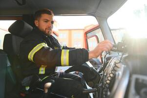 Feuerwehrmann mit Radio einstellen während Fahren Feuer LKW foto