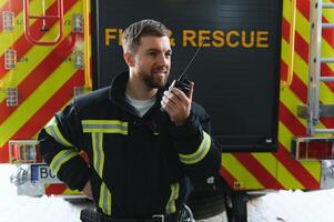 Feuerwehrleute Mann im ein schützend passen in der Nähe von Feuer LKW. Schutz, Rettung von Achtung. Feuer Bahnhof foto