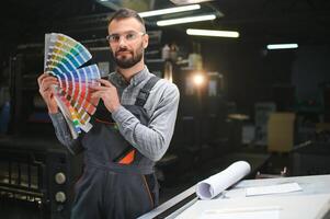 Mann Arbeiten im Drucken Haus mit Papier und Farben foto