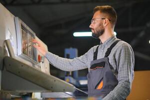 Drucken Haus Innere mit modern Versatz drucken Maschine und Operator im Arbeiten Uniform Überprüfung Qualität und steuern Prozess von drucken foto