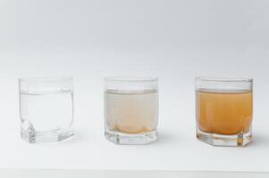 Wasser Filter. Konzept von drei Brille auf ein Weiß Hintergrund. Haushalt Filtration System. foto