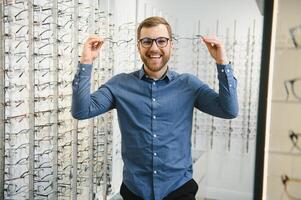 Schuss von ein gut aussehend bärtig Mann versuchen auf Neu Brille beim das Brillen shop.man Kauf Brillen.Gesundheit, Sehvermögen, Vision, Mode, Einkaufen foto