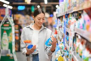 jung Frau im Haushalt Chemie Abteilung von Supermarkt foto