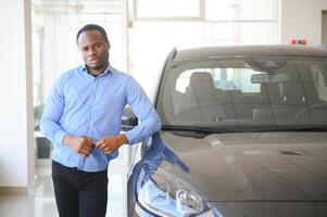 gut aussehend afrikanisch Mann wählen ein Neu Auto beim das Händler foto