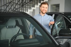 jung Mann, Verkauf elektrisch Autos im das Ausstellungsraum. Konzept von Kauf umweltfreundlich Auto zum Familie foto