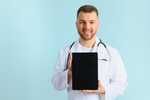 Nahansicht von zeigen ein Tablette halten im Hände durch ein männlich Arzt Wer hat ein ziemlich Smiley. foto