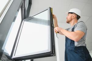 Fachmann Meister beim Reparatur und Installation von Fenster, beim arbeiten. foto