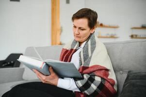 Senior Frau lesen Buch beim heim. foto